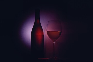 Artistic silhouette of a bottle and glass with low key lighting