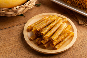 Thai dessert Mango sheet ,Sun dried mango paste roll on white plate