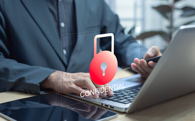 Businessman using laptop with virtual key and confidential access for corporate files, illustrating...
