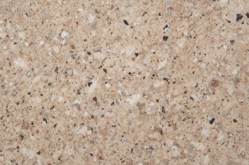 Close-up of polished beige granite featuring white speckles on natural stone surface.