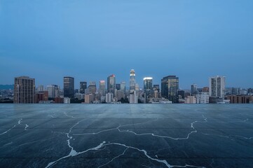 Creative business concept with empty marble floor and panoramic modern city skyline during early morning blue light.