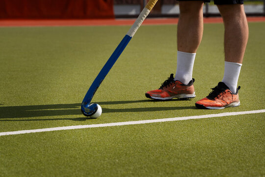 A hockey player hitting the ball in the stadium. Candid close up  Photo