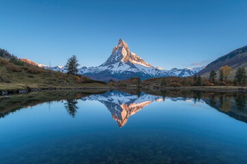 Mountain reflected in a lake under a clear blue autumn sky