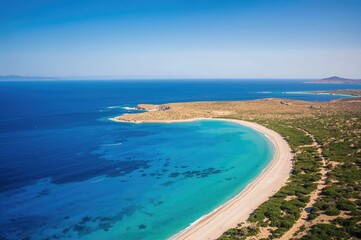 Coastal scenery with clear blue waters and lush greenery under a bright summer sky