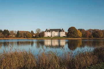 Obraz premium Autumn view of a manor by a serene lake