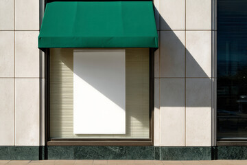 Storefront with green awning and blank white sign. Modern architectural facade with window and shadow.