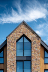 Obraz premium House Facade: Architectural Detail of a Modern Home with a Triangular Window and Brickwork Design