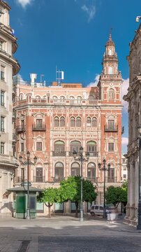 Morning timelapse of Central de Telefonica and the Town Hall in Plaza de San Francisco, Seville. Casa Consistorial, a masterpiece of Plateresque architecture with tram under a blue cloudy sky