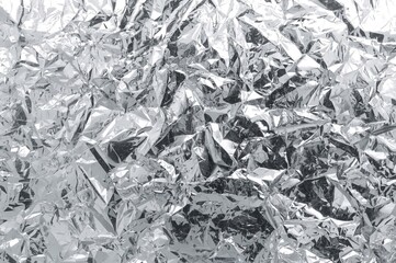 Crinkled aluminum foil with blurred texture, metallic surface background, silver distressed design, patterned material, shiny chrome-like sheet, grey tone, space for text, out of focus