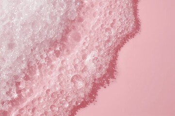 Fototapeta premium Close-up of cosmetic foam with bubbles on a pastel pink background. Texture of cleansing skincare lather.