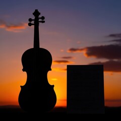 Violin silhouette against a dramatic sunset sky