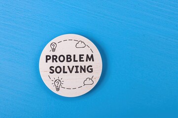 Concept of resolving issues with question mark and light bulb symbols on circular wooden piece against blue backdrop. Innovation, creativity, and idea generation for business solutions.
