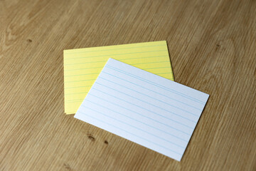 Yellow and white blank index cards on the office desk. Empty, at work, office supplies.