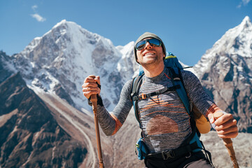 Portrait of smiling Hiker man on Taboche 6495m and Cholatse 6440m peaks background with trekking...