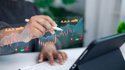 Businessman hand analyzing stock market data on futuristic digital screen with tablet computer
