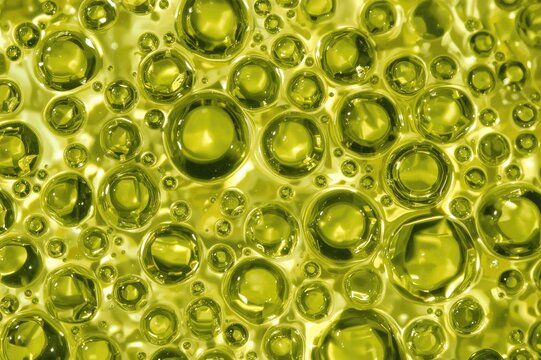 Close-up of green liquid oil bubbles with a natural texture background