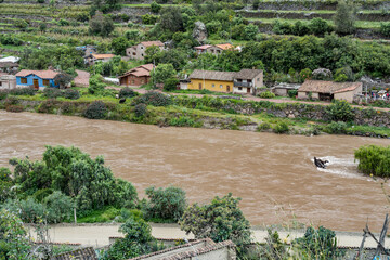 Scenic view of the Urubamba River flowing through the Sacred Valley alongside the Ollantaytambo town, Peru.