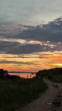 Sunset view over Mekong River with people and vehicle on riverside Laos