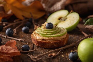 Nutritious snacks featuring green apple wedges topped with peanut butter and fresh blueberries on a wooden surface