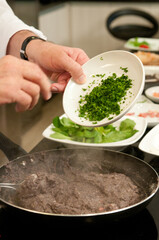 Chef na cozinha fazendo o preparo de varios pratos da cozinha mediterranea 
