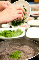 Chef na cozinha fazendo o preparo de varios pratos da cozinha mediterranea 