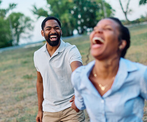 Obraz premium Happy active young black couple having fun walking running holding hands and bonding in park or nature outdoors