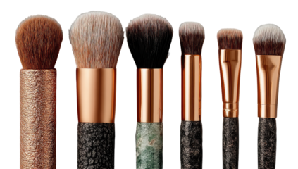 Close-up of seven makeup brushes.  Handles are copper-colored, textured.  Brushes are various sizes, round or slightly oval.  Natural fibers visible