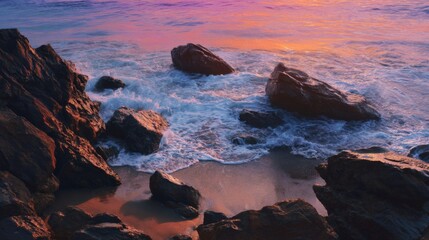 Obraz premium Waves crash against rocks on a sandy beach under a pastel sunset sky Ocean