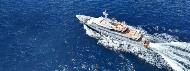 Aerial drone ultra wide tracking photo with copy space of beautiful modern super yacht with wooden...