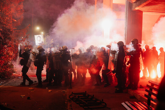 Protestors face police in a tense standoff during a nighttime demonstration in an urban area