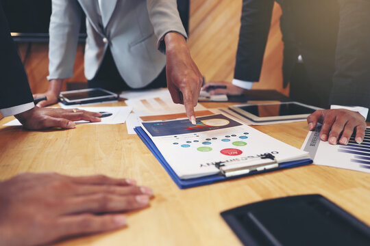 A group of business people are meeting to analyze data for marketing plan