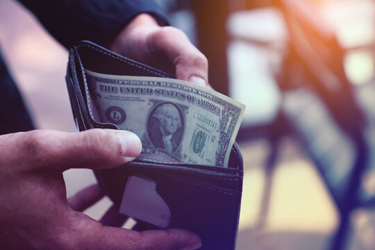 Hand Holding Cash in a Wallet, The Last Dollar