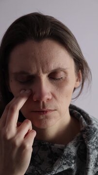Female tapping EFT technique under eye point on a face. Vertical video.