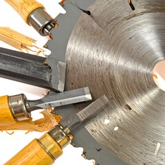Wooden handles and metal tools surround a circular saw blade, scattered wood chips and shavings.