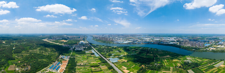 Suizhou City China shows a wide river flowing through green landscapes towards the city buildings...
