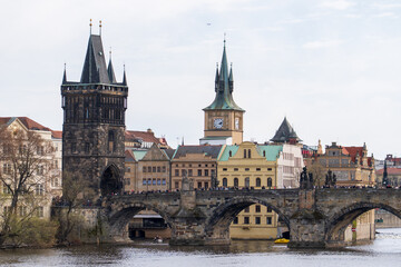 Fototapeta premium Prague, Czech Republic - April 5, 2025: View of the Charles Bridge and the Vltava River with ships passing by