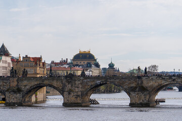 Prague, Czech Republic - April 5, 2025: View of the Charles Bridge and the Vltava River with ships passing by