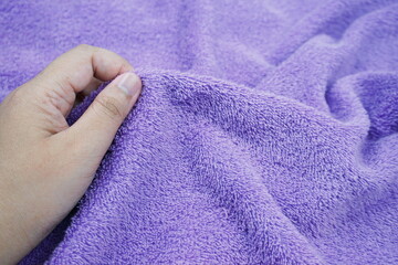 hand touching soft terry towel, purple terry towel