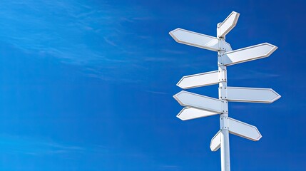 Blank directional signs against blue sky