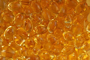 Close-up of many golden Omega-3 fish oil capsules.
Concept of: Healthy supplements.