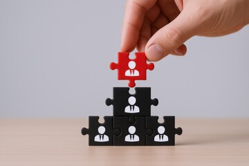 Hand Placing Red Puzzle Piece Atop Team Hierarchy Representing Leadership and Recruitment