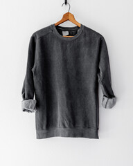 Cozy vintage-style dark gray charcoal black crewneck sweatshirt on wooden hanger, back view,...
