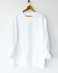 Cozy vintage-style white crewneck sweatshirt on wooden hanger, back view, minimalist fashion...