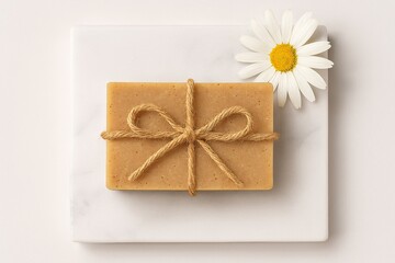 Handmade natural soap with rope bow and daisy flower on marble background for organic skincare