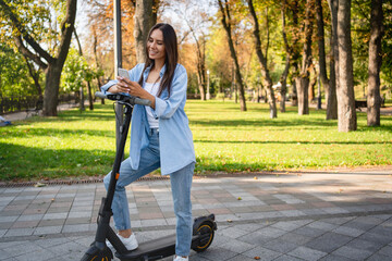 Full length of woman using smartphone online application looking a map during ride on electric...