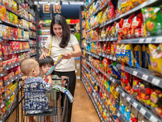 woman is shopping with two children in a grocery store
