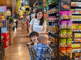 woman and two children are shopping in a grocery store
