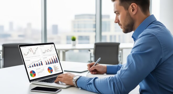 Confident businessman analyzes financial data charts on laptop in modern office, planning strategy