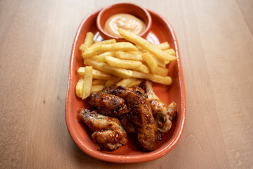 Crispy chicken wings and golden fries with a tasty dipping sauce