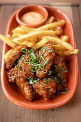 Crispy fried chicken wings served with golden fries and dipping sauce